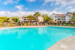 a large blue pool with chairs and condos at Green Arbor in North Myrtle Beach