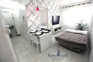 a white living room with a table and a bed at Paraiso, paz e conforto é aqui! Seja bem vindo(a). in Maceió