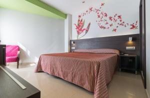 a bedroom with a bed with a red blanket at Hotel Porto Calpe in Calpe