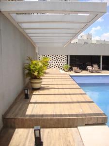 a wooden walkway leading to a pool on a building at Edificio Crystal Place Ap1405 in Goiânia