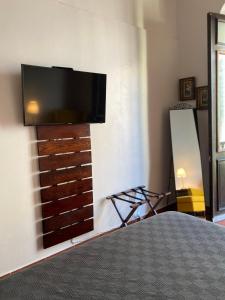 a bedroom with a flat screen tv on a wall at 352 Guest House Hotel Boutique in San Juan