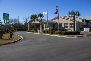默特尔比奇SureStay Hotel by Best Western North Myrtle Beach的棕榈树建筑前的街道
