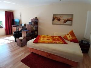 Un dormitorio con una cama y una sala de estar. en Sonnige Ferienwohnung am Wald Büdnerreihe, en Heiligenhagen