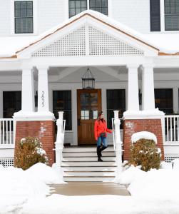 a woman standing on the steps of a house at Kimpton Taconic Hotel, an IHG Hotel in Manchester