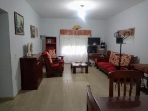 a living room with red couches and a tv at Casa a 5 km de Villa de Las Rosas in Las Tapias