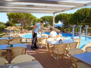 two men standing on a patio near a swimming pool at Quinta Pedra Dos Bicos in Albufeira