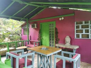 um pátio com uma mesa e cadeiras e uma porta verde em CHEZ NOUS em Puerto Carrillo