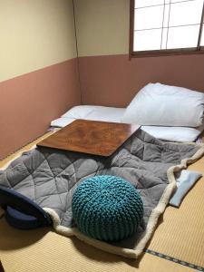 Una cama con una mesa encima. en Umeoka Ryokan, en Nagano