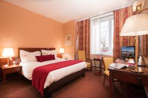 Cette chambre comprend un lit, un bureau et une télévision. dans l'établissement Hotel De La Matelote, à Boulogne-sur-Mer