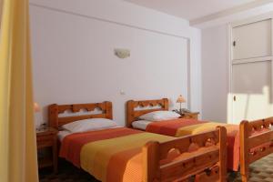two beds sitting next to each other in a bedroom at Apollon Apartments in Akrogiali