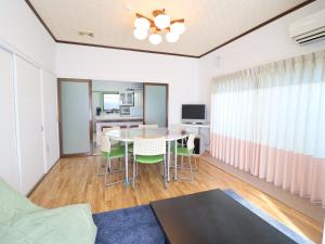 sala de estar con mesa y sillas en Friendly Guest House Kawakin en Minamiboso