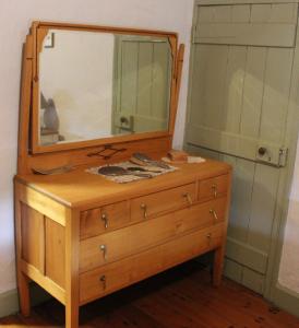 a wooden dresser with a mirror on top of it at Bakehouse Burra in Burra