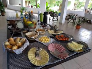 a table with many plates of food on it at Maresias Praia Hotel in Maresias
