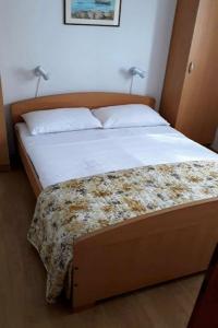 ein Bett in einem Schlafzimmer mit zwei Lampen oben in der Unterkunft Apartments Amalija-50m close to sea in Rogoznica