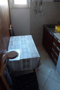 eine kleine Küche mit einem Tisch und einem Waschbecken in der Unterkunft Apartments Amalija-50m close to sea in Rogoznica