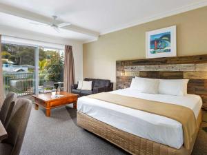 1 dormitorio con 1 cama y sala de estar en Blueys Motel, en Blueys Beach
