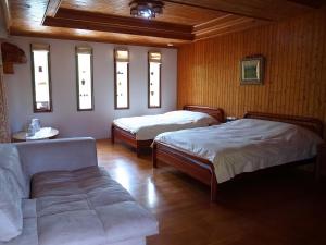 um quarto com duas camas, um sofá e janelas em The LianFamily Teahouse B&B台東民宿001號 em Yung-an-ts'un