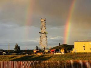 a rainbow in the sky with a tower and a car at Tower 64 Motel & RV in Trinidad