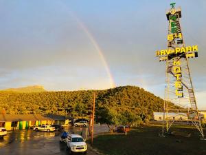 a rainbow over a parking lot with a bar park sign at Tower 64 Motel & RV in Trinidad