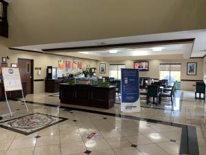 a lobby with a restaurant with tables and chairs at Comfort Suites Beaumont I-10 in Beaumont