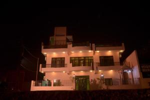 un gran edificio blanco con una puerta verde por la noche en Ganga Monastery, en Varanasi