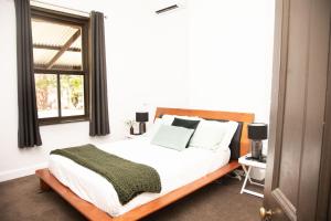 1 dormitorio con cama y ventana en The Glen Farmhouse on Ovens River, en Wangaratta