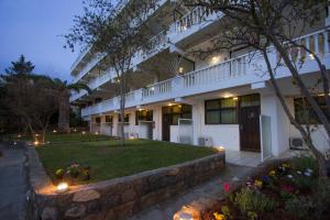 a large white building with lights in front of it at Apollon Apartments in Akrogiali