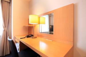 a room with a desk with a mirror and a lamp at Richmond Hotel Tokyo Shiba in Tokyo