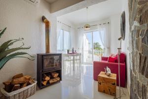 a living room with a fireplace and a red couch at Casa Beatriz in Carvoeiro +13 photos