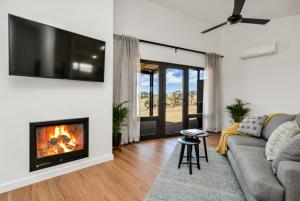 sala de estar con sofá y chimenea en Old Bull Creek Luxury Retreat, en Strathalbyn