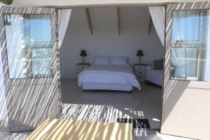 a bedroom with a bed and a balcony at Serenity in Velddrif
