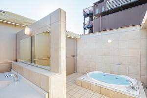 uma casa de banho com uma banheira e um lavatório em Kyoto City Gardens Hotel em Quioto