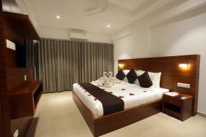 a bedroom with a large bed with red roses on it at Iswarya Residency in Kottayam