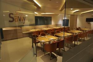 a restaurant with wooden tables and chairs and a screen at Iswarya Residency in Kottayam