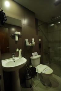 a bathroom with a sink and a toilet and a shower at Iswarya Residency in Kottayam