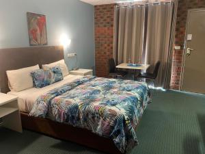 a hotel room with a bed and a table at Zero Inn Motel in Nhill