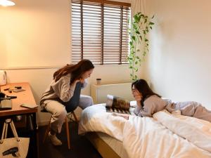 two girls sitting on a bed in a room at Hotel Pacific Kanazawa in Kanazawa