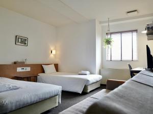 a hotel room with two beds and a window at Hotel Pacific Kanazawa in Kanazawa +37 photos