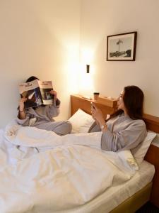 a woman laying in bed while holding a box at Hotel Pacific Kanazawa in Kanazawa