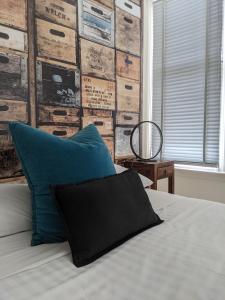 ein Bett mit einem blauen Kissen und einer Holzwand in der Unterkunft The Old Federal Coffee Palace in Launceston
