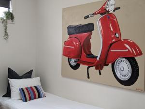 ein Bild eines roten Motorrollers, der an einer Wand hängt in der Unterkunft The Old Federal Coffee Palace in Launceston