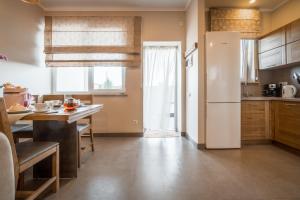 a kitchen with a white refrigerator and a table at Villa Aquamarin Buhaz in Zatoka