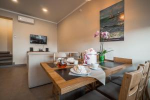 a dining room with a wooden table and chairs at Villa Aquamarin Buhaz in Zatoka