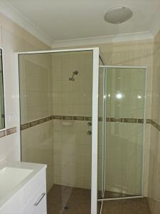a bathroom with a shower, sink, and toilet at Albion Hotel in Kalgoorlie