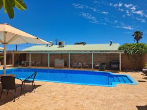 a blue and white swimming pool in a backyard at Albion Hotel in Kalgoorlie