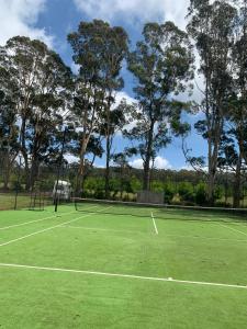 um campo de ténis com árvores ao fundo em Misty Farms Barn em Robertson