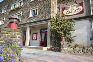 un edificio con un cartel en el costado en Hotel Restaurant Le Lion d'Or, en Saint-Hilaire-du-Harcouët