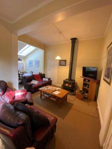 a living room with a couch and a wood stove at Olinda Country Cottages in Olinda