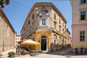 an old building with an umbrella in front of it at Dante paradiso in Pula