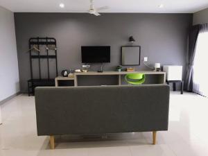 een woonkamer met een bank en een tv bij Grandsiri Resort KhaoYai in Mu Si